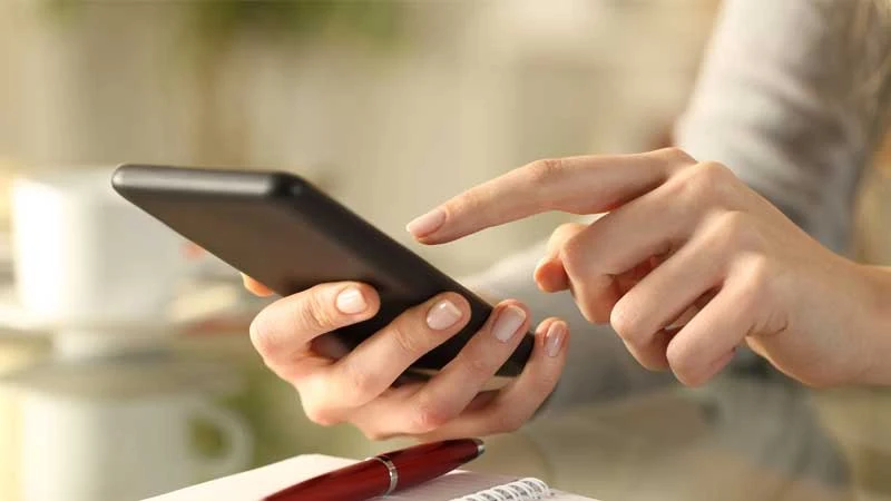 スマートフォンで予約する女性