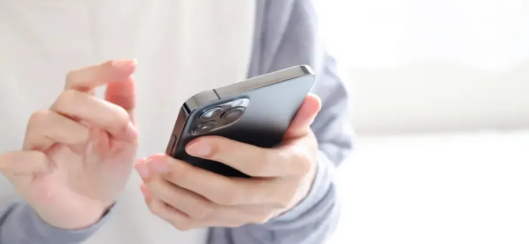スマートフォンを操作する手元