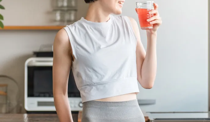 キッチンで飲み物を飲む女性
