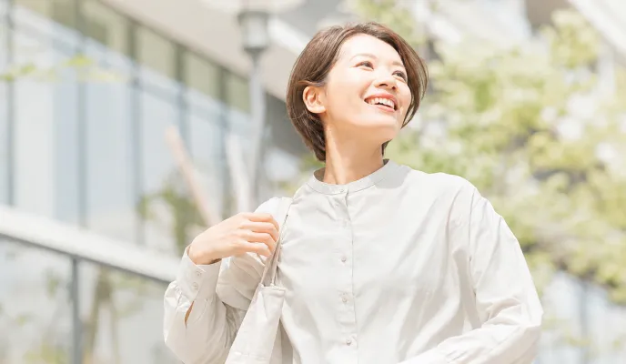 屋外で笑顔を見せる女性