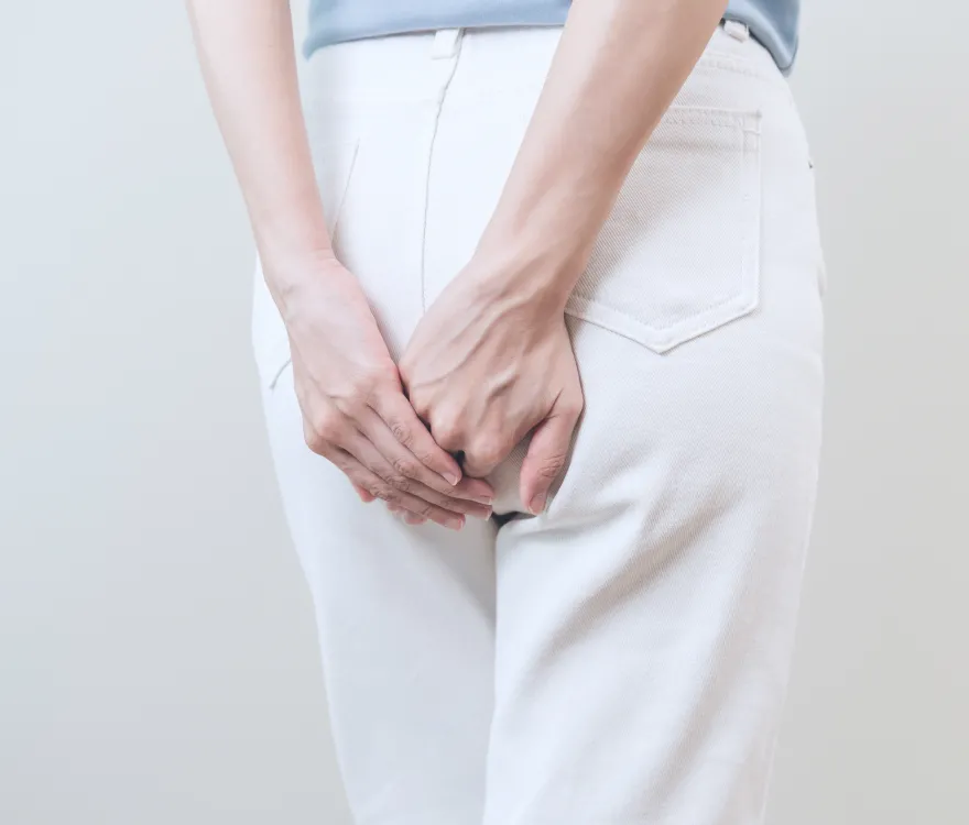 お尻を押さえる女性