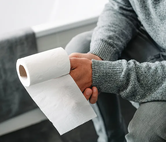 お尻を押さえる男性と問診する医師