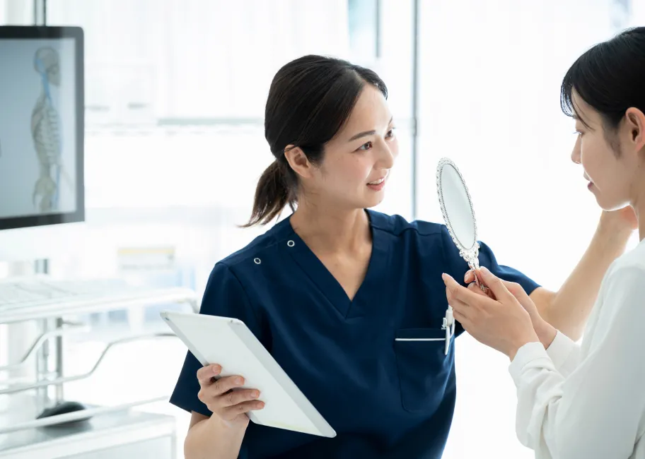 鏡を使って患者さまに説明する看護師
